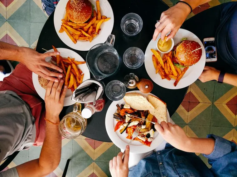 Overhead view of a lively casual table with burgers and fries
