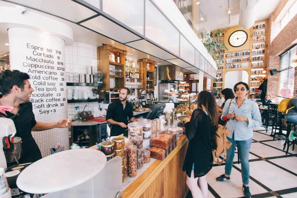 Staff helping customers at a bright café counter